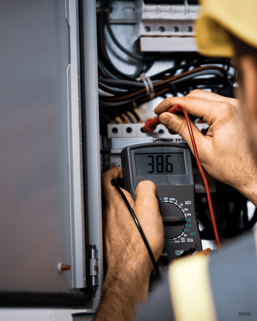 Électricien SD Elec en diagnostic sur un tableau électrique à Lyon avec multimètre